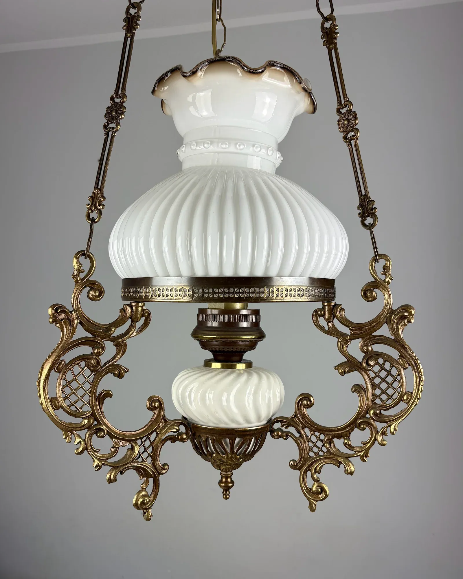Vintage Rococo style brass hanging oil lamp with ribbed milk glass shade and ceramic font, front view