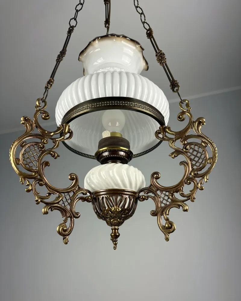 View from below into the milk glass shade of the brass hanging lamp, with bulb socket and ceramic font