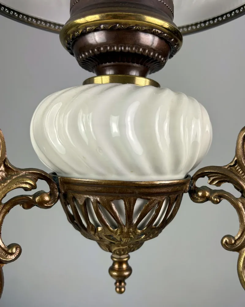 Close-up of the swirl-ribbed white ceramic font set in a pierced brass cup with a turned finial
