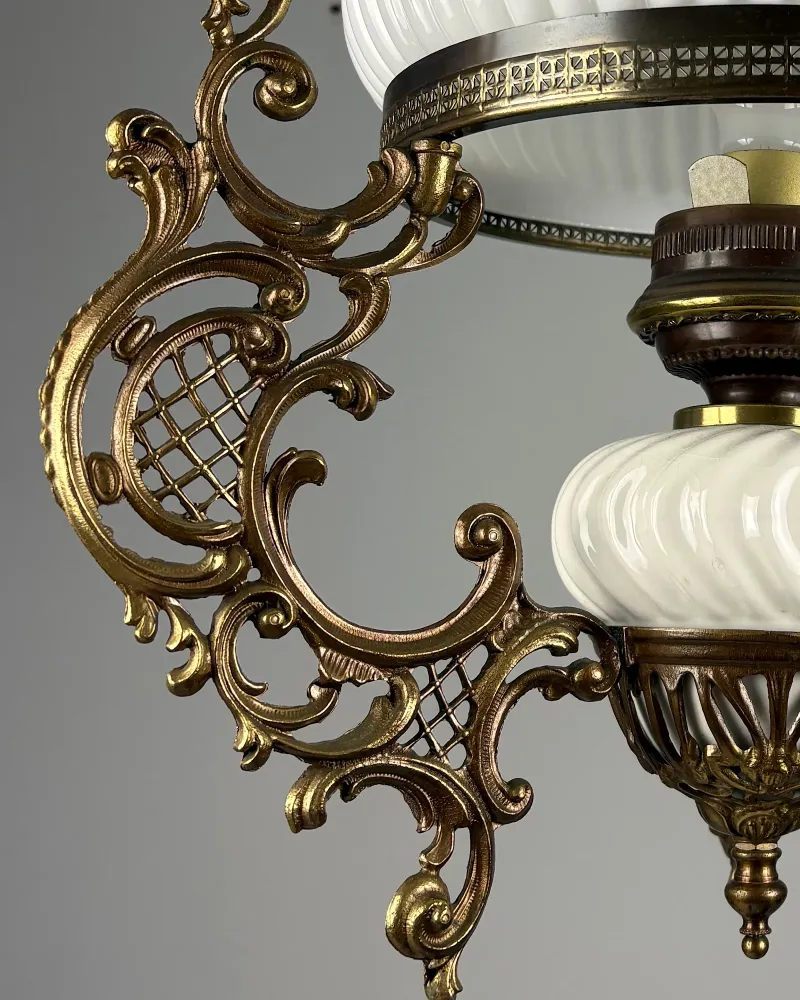 Detail of the cast brass Rococo frame with lattice panels and scrolled leaf ornament beside the ceramic font