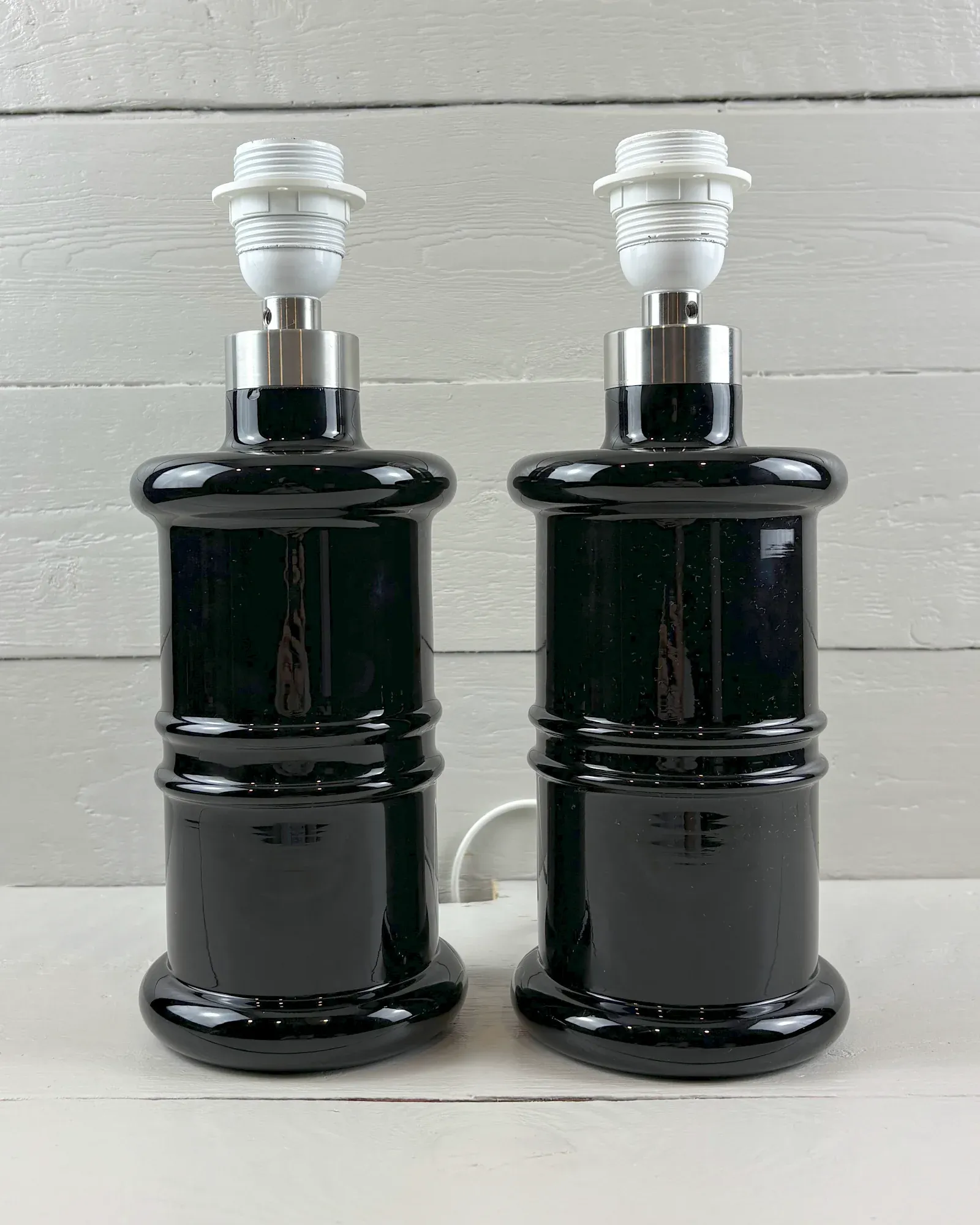 Pair of Holmegaard Apotheker black glass table lamps by Sidse Werner, shown without shades, front view