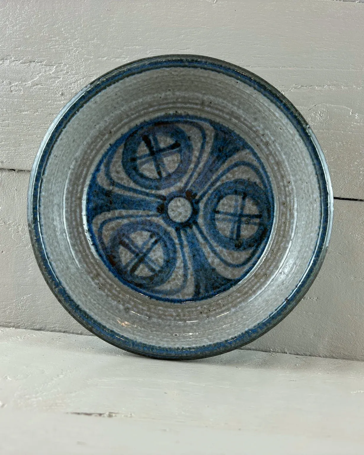 Top view of a 1960s Søholm bowl: three blue lens-shaped motifs around a central dot and a blue rim