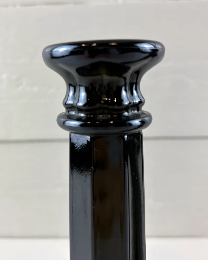 Close-up of the capital-like candle cup and ringed collar on a black pressed glass column candlestick