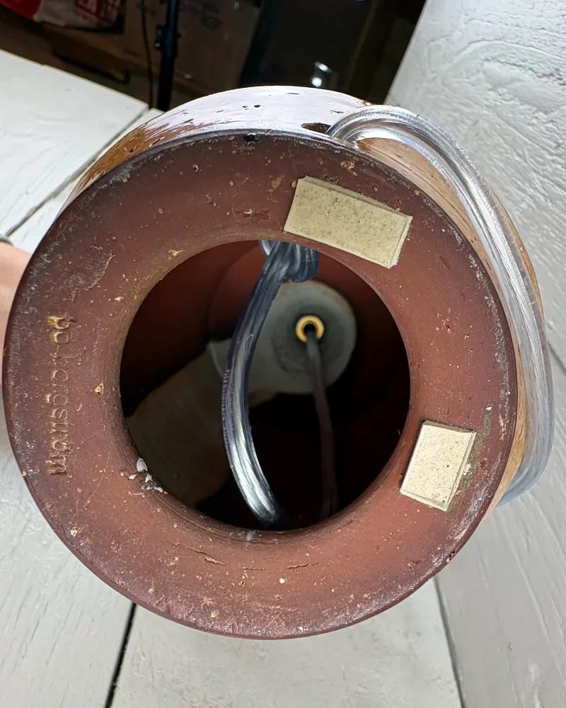 Underside of a Bo Borgström stoneware table lamp showing the hollow base, clear cord and socket fitting