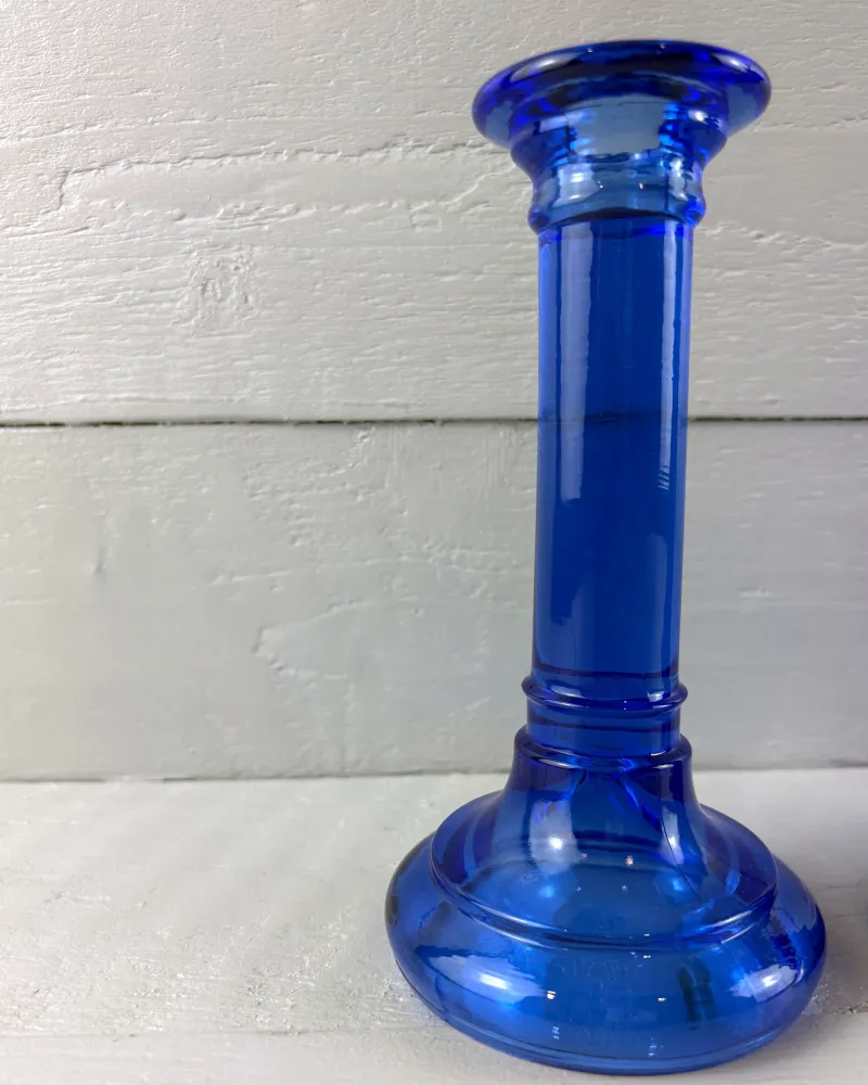 Cobalt glass candlestick in a lighter azure blue with a broad stepped foot and ringed stem