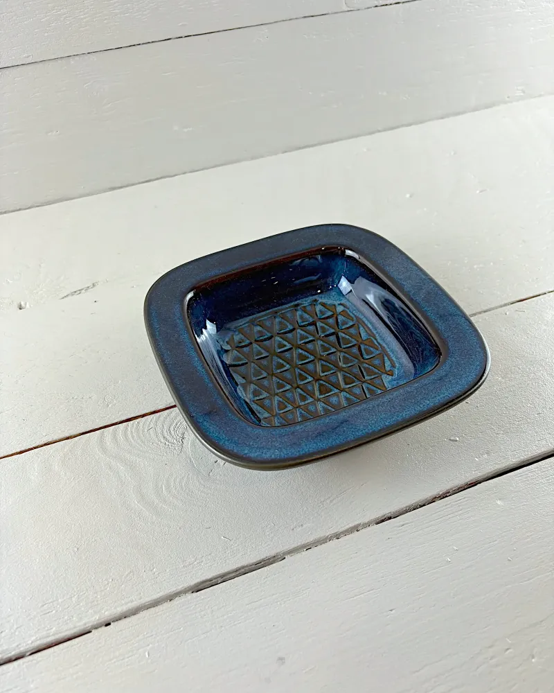 Square Søholm stoneware bowl by Einar Johansen seen at an angle, blue glazed rim and patterned centre