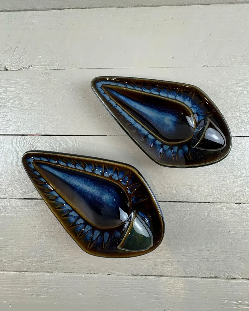 Two Soholm stoneware wall candle holders lying flat, cobalt glaze and dark brown rims seen from above