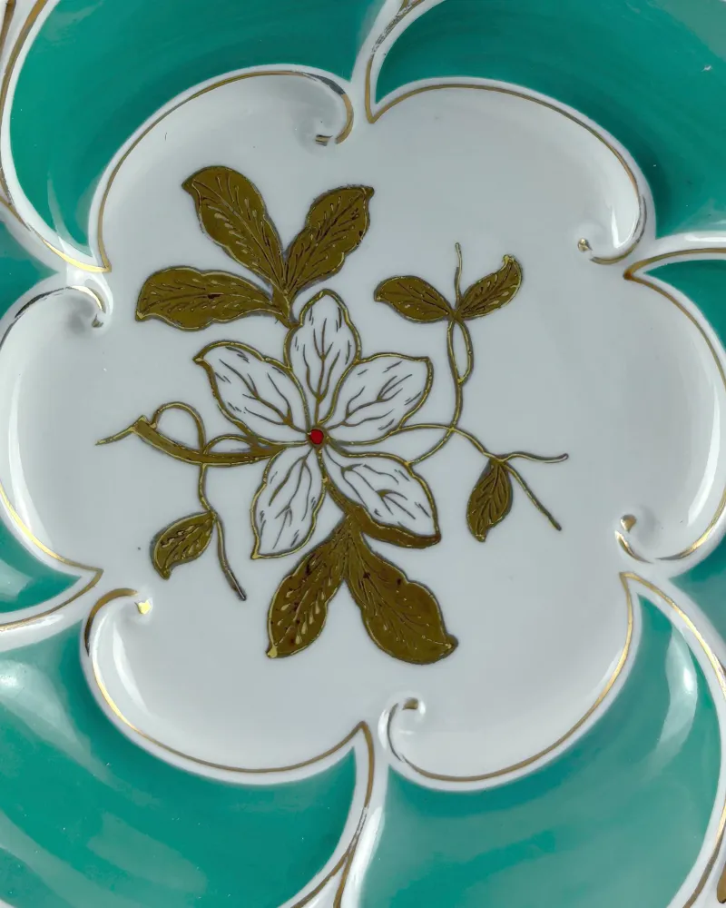 Close-up of the hand-painted gilt flower with brown-gold leaves at the centre of a Henneberg porcelain dish