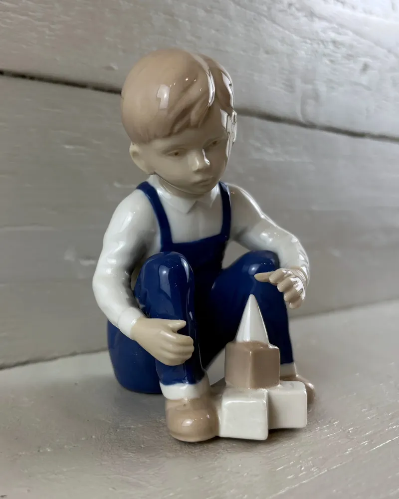Gräfenthal porcelain boy with building blocks seen from the front left, roof-shaped block beside his foot