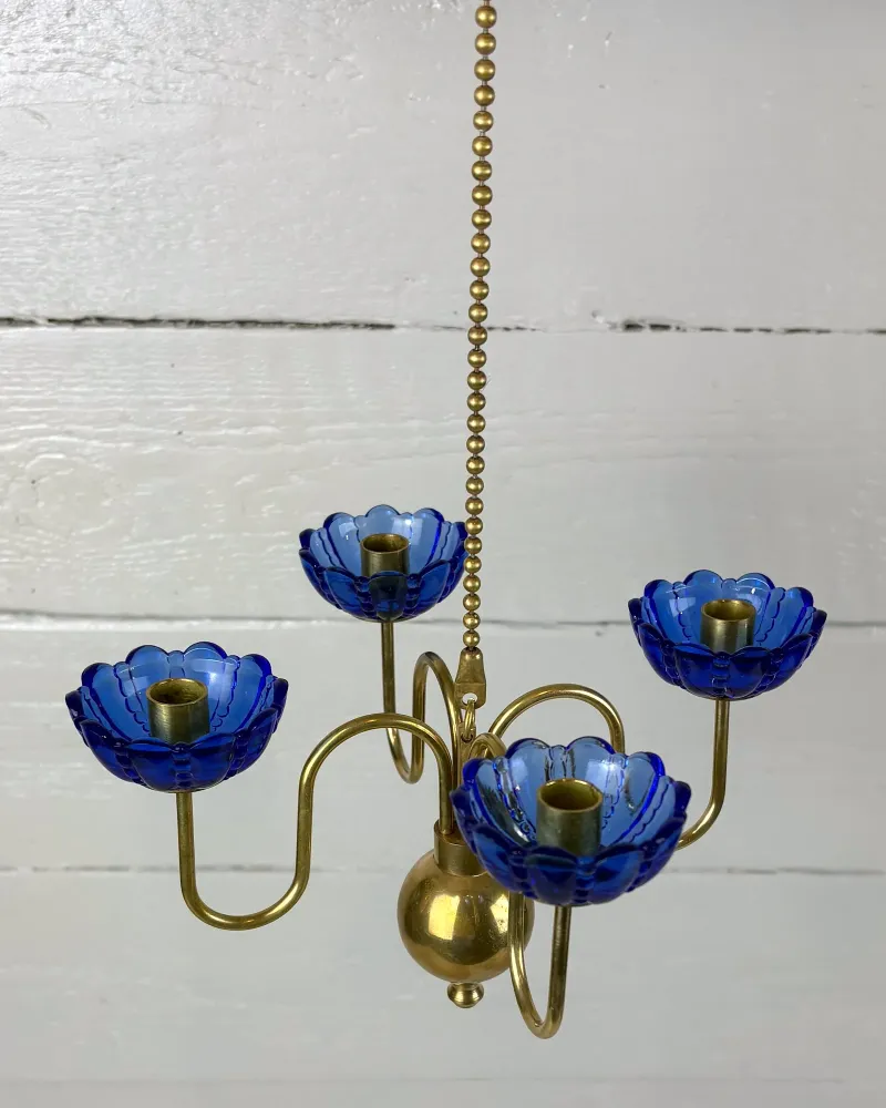 View from above into the four blue glass candle cups of a Swedish brass hanging candelabra