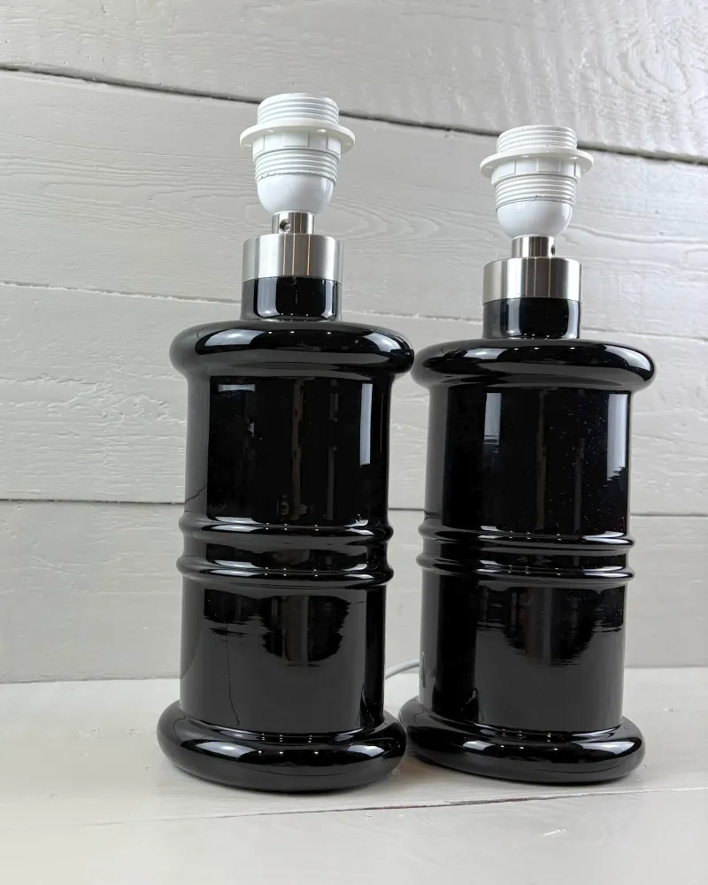 Pair of Holmegaard Apotheker black glass table lamps seen from a slight angle, without shades