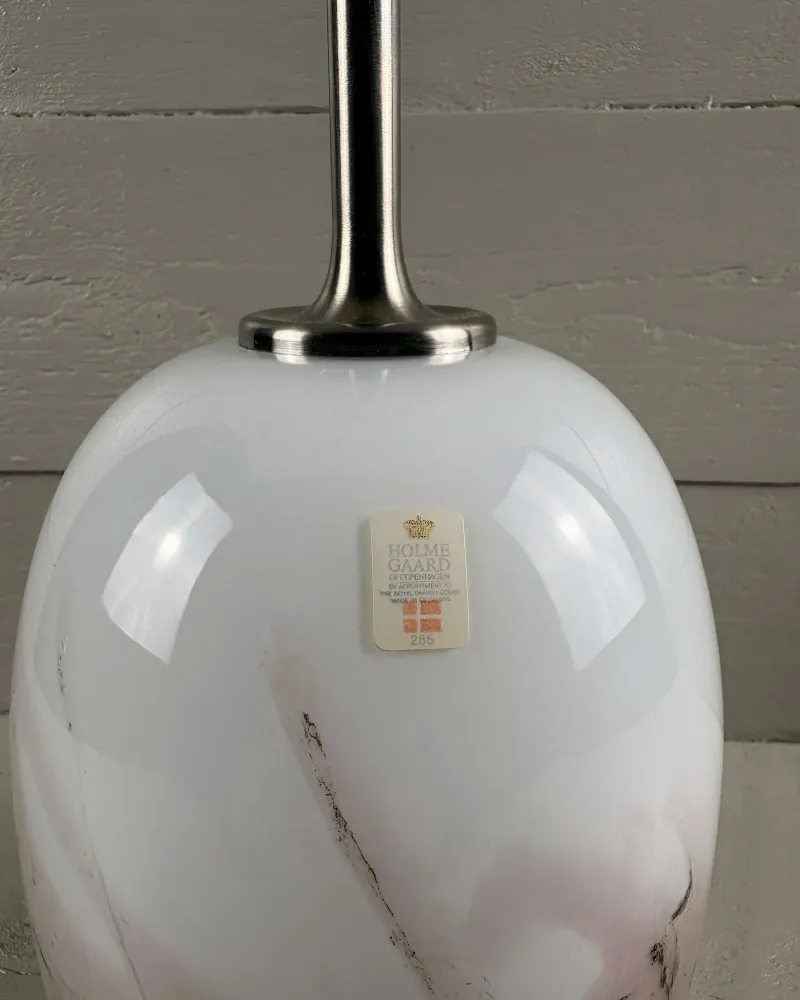 Close-up of Sakura glass base with brushed steel collar, stem and Holmegaard paper label