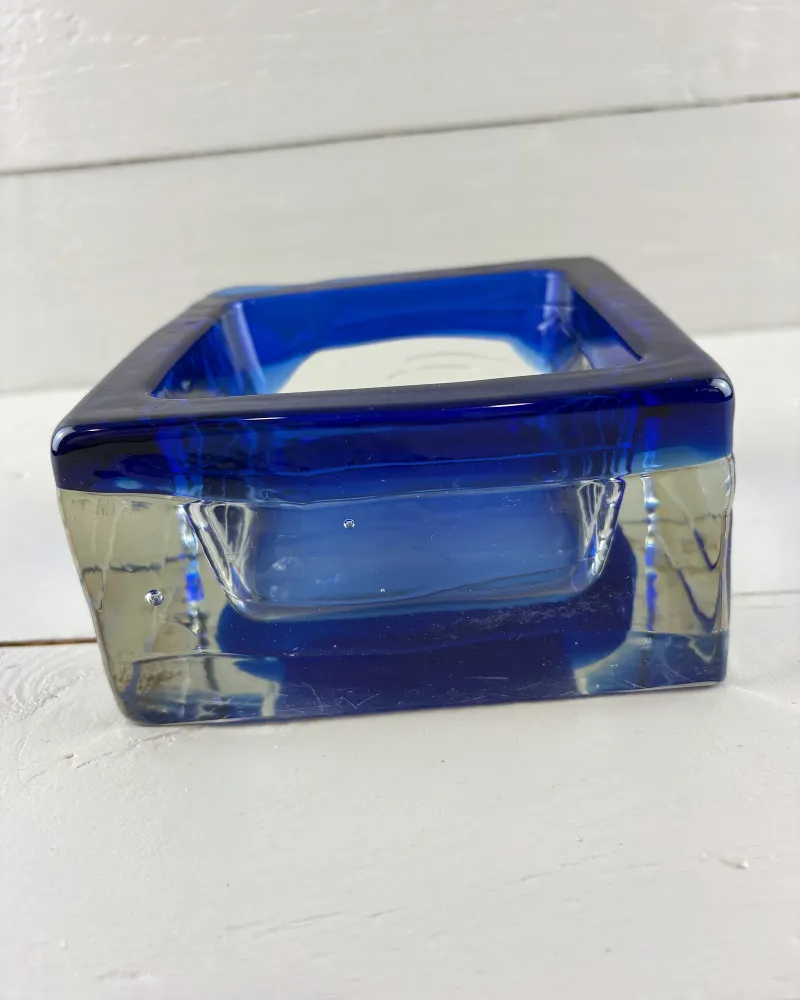 Side profile of a Reijmyre Sargasso glass bowl, blue rim above thick clear lower walls with air bubbles