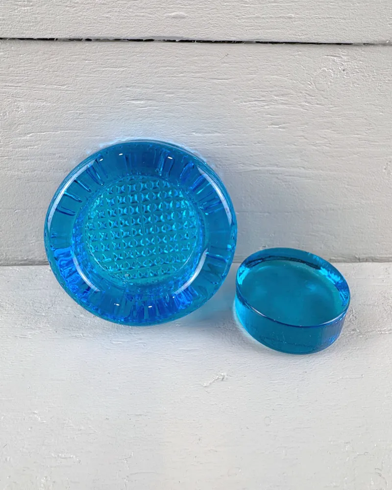 Top view of the Mantorp paperweight base with radial ribs around the recess, next to its smooth glass disc