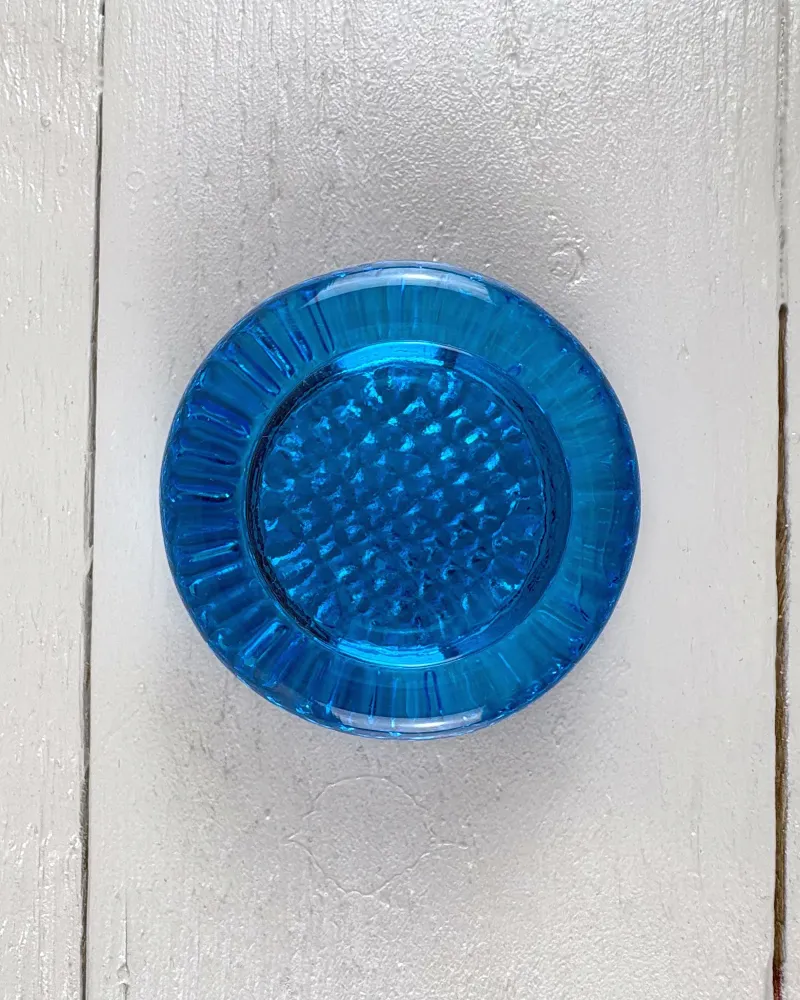 Close-up of the Mantorp paperweight base from above: studded recess framed by a thick rim with radial ribs