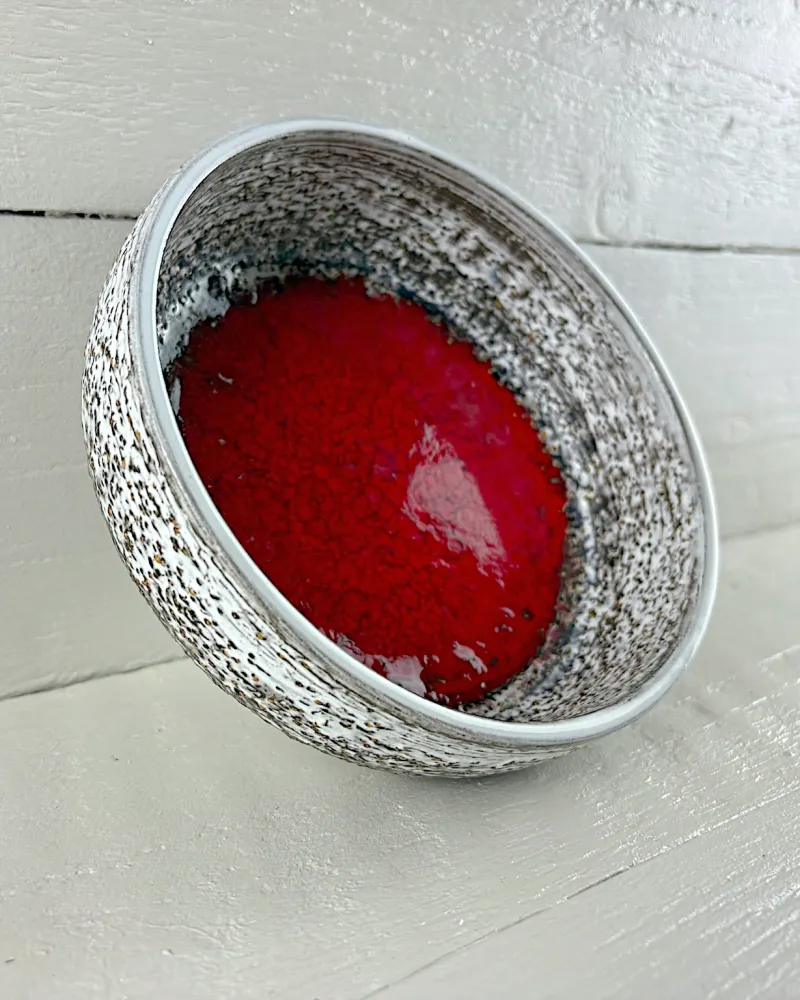 Upsala-Ekeby Gloria ceramic bowl by Mari Simmulson, tilted to show the glossy red glaze inside