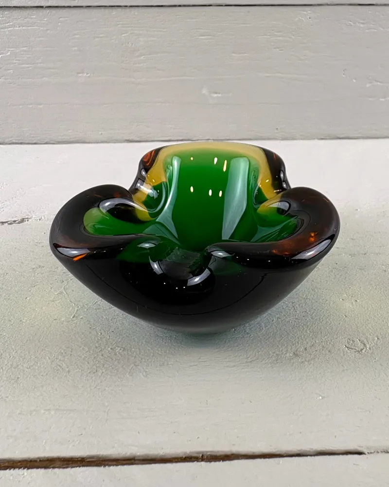 Murano-style sommerso glass trefoil ashtray, low front view of the dark rim and green interior