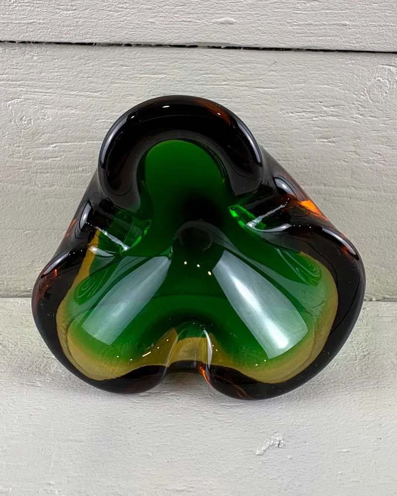 Looking into a Murano-style sommerso glass trefoil ashtray with green core, yellow band and brown rim