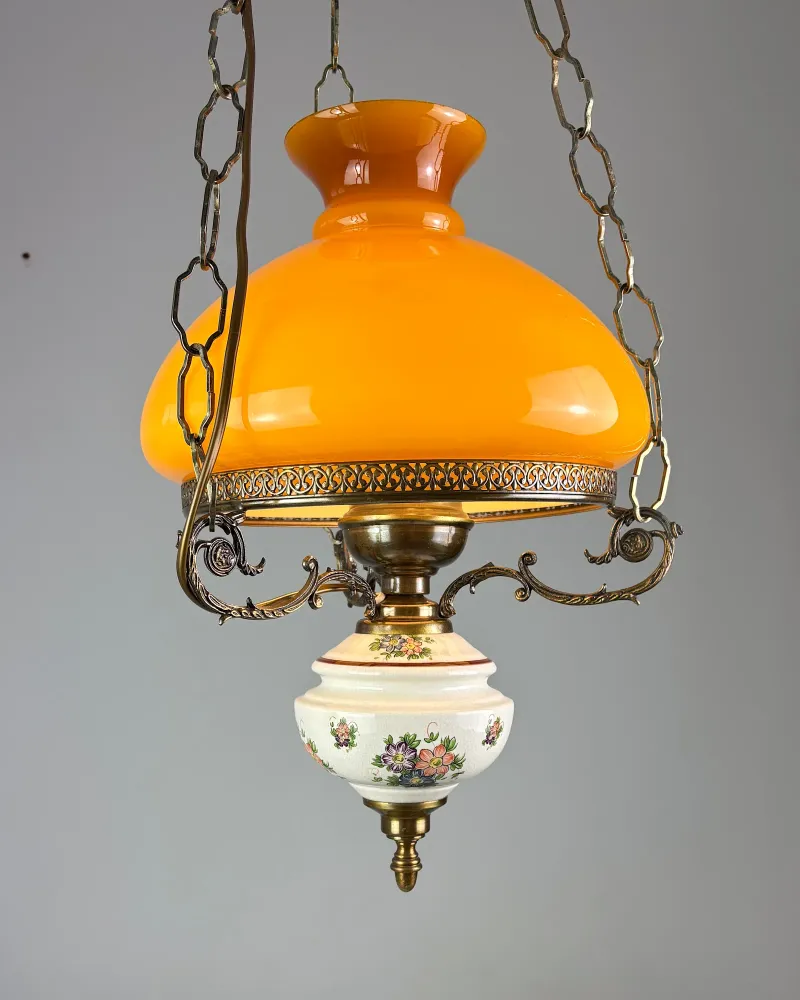 Amber opal glass shade and pierced brass gallery of an oil lamp style pendant light, seen from below