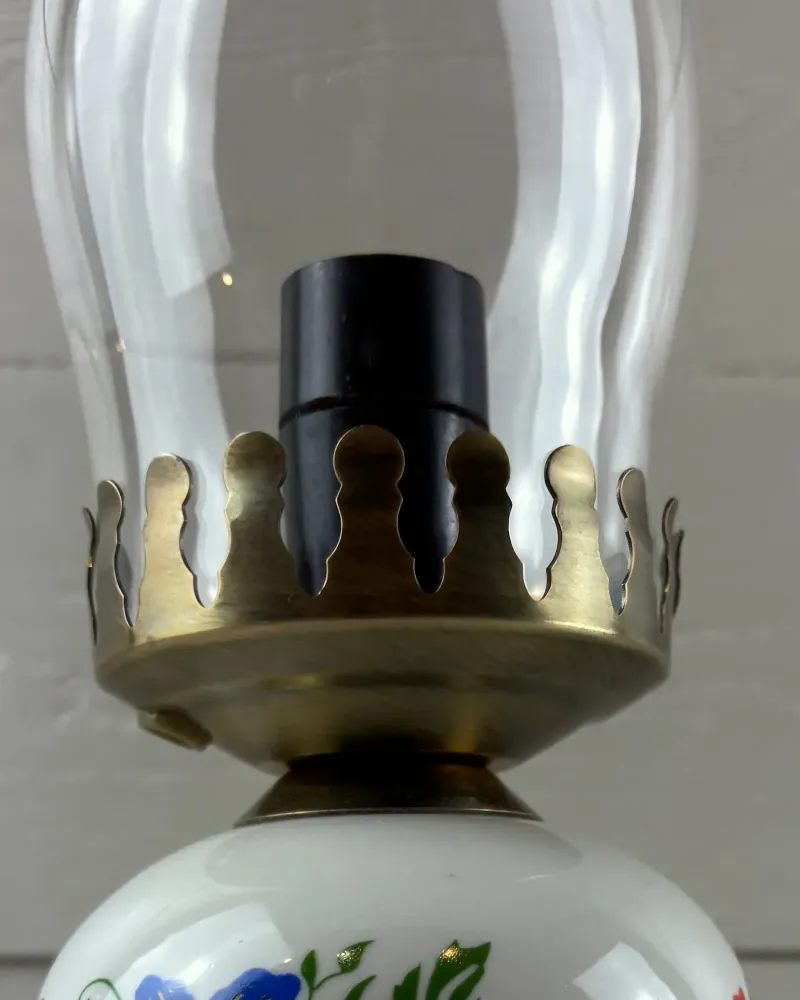 Scalloped brass-toned crown and black socket inside the glass chimney of a vintage Polish table lamp