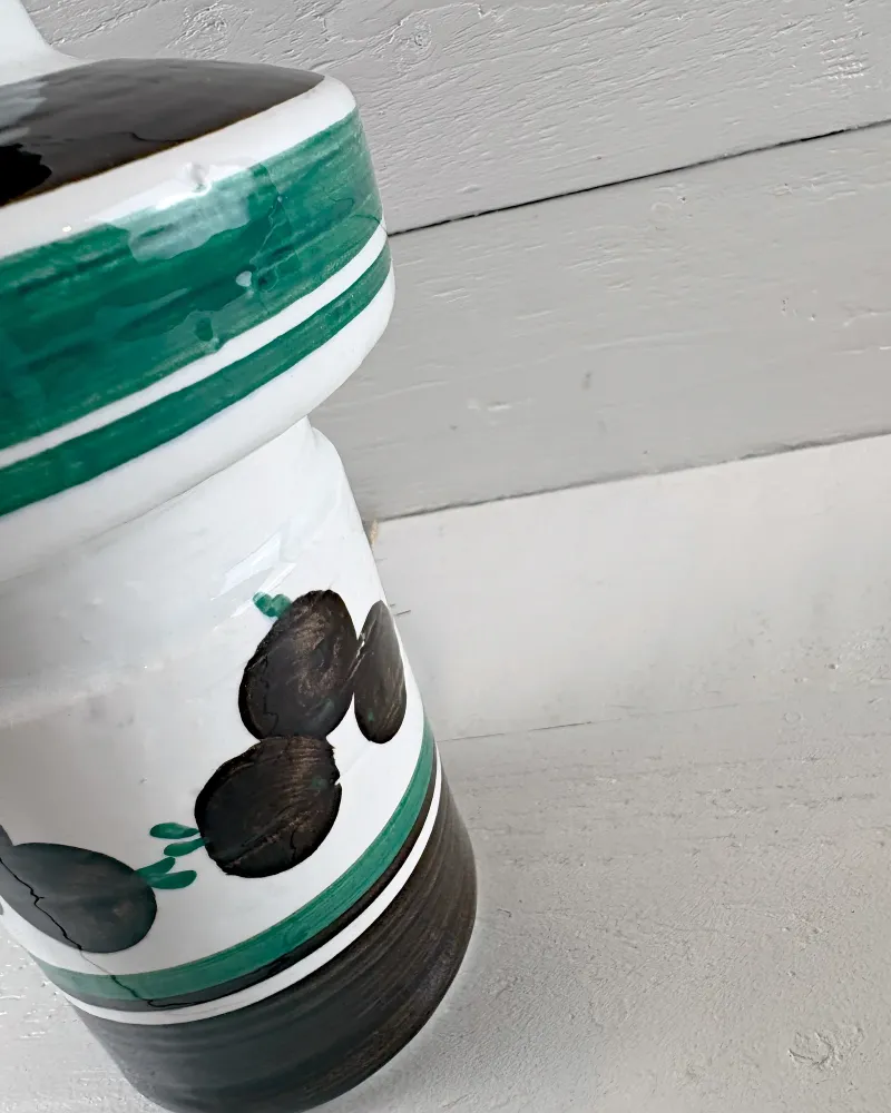 Close-up of the green-banded shoulder of a Rorstrand lamp base with a small glaze flaw and fine cracks in the paint