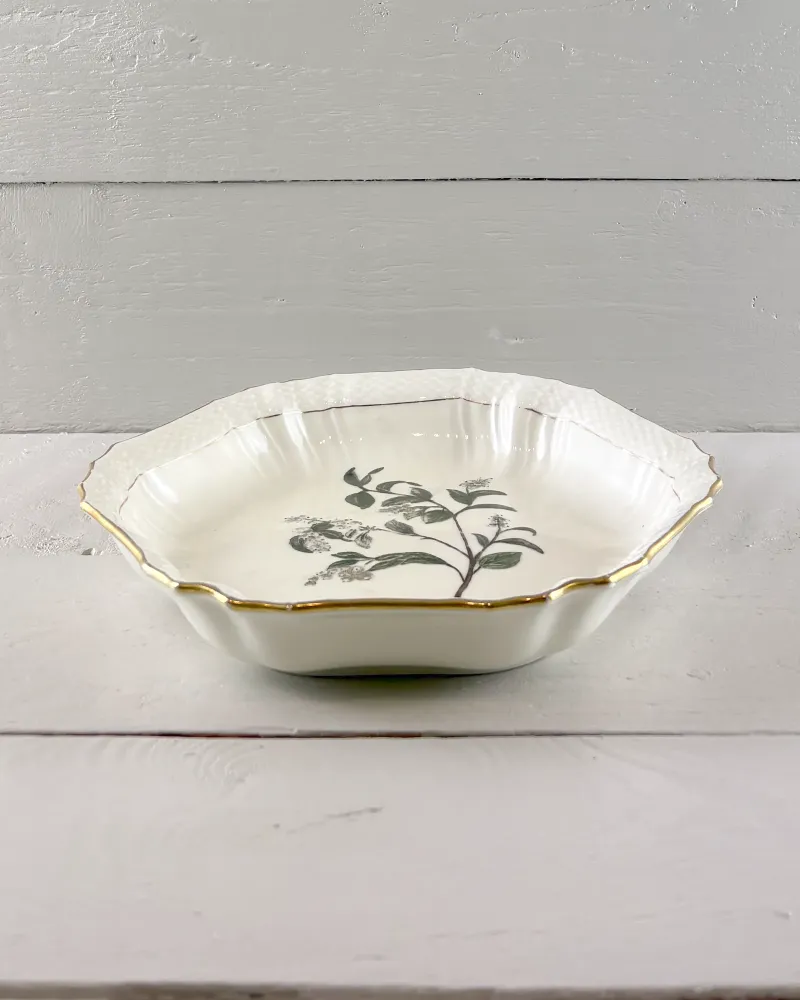 Side profile of a Royal Copenhagen hexagonal porcelain dish with scalloped gilt rim and shallow form