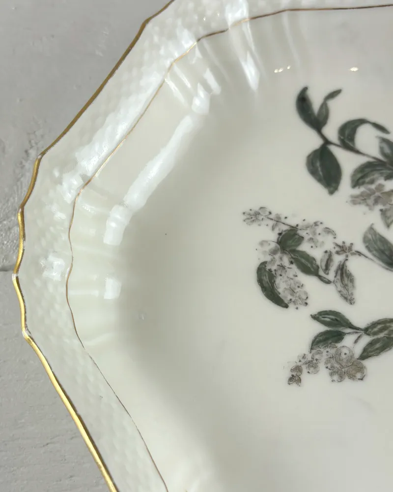 Close-up of the basket-weave relief rim and gilt edge on a Royal Copenhagen porcelain dish