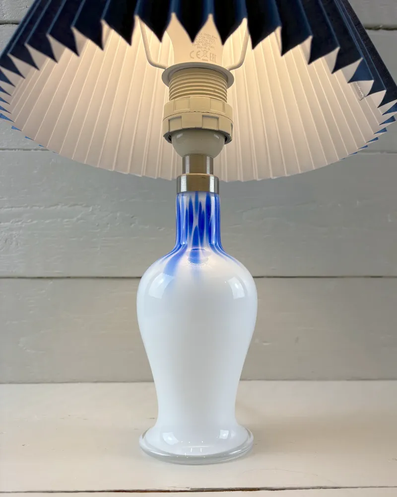 Royal Copenhagen Torino Lille table lamp switched on, warm light glowing through a pleated shade