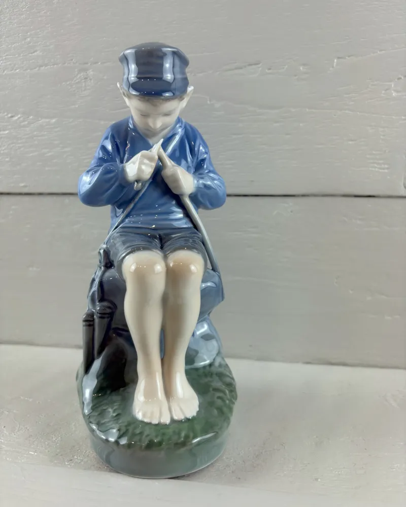 Royal Copenhagen Whittler boy figurine, model 905, blue jacket and peach skin tones, seen straight from the front