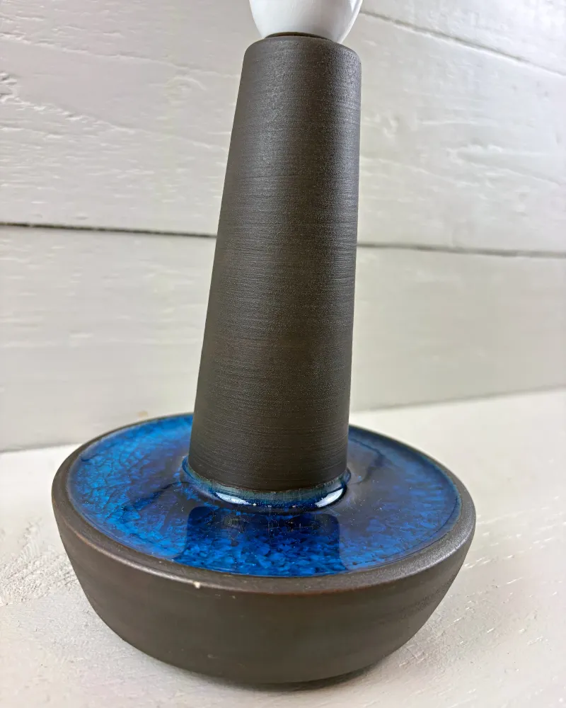 Soholm 1072 stoneware lamp base in three-quarter view, tapering stem rising from a blue crackle glaze dish