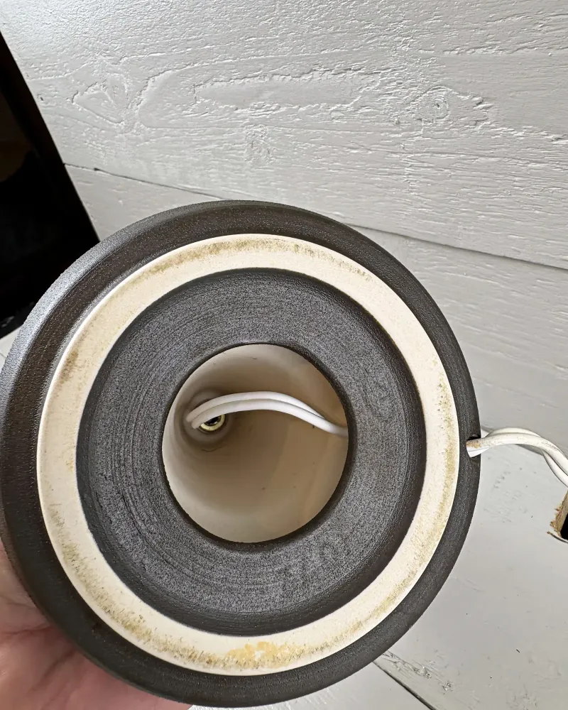 Underside of Soholm 1072 lamp with unglazed cream foot ring, dark stoneware centre and cord leaving the foot