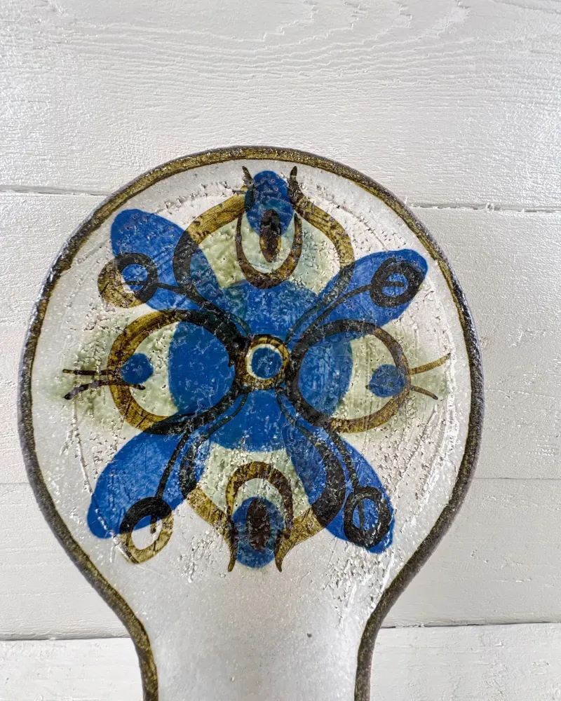 Close-up of hand-painted cobalt blue and sage green flower on Soholm 3220 candle holder, white glaze