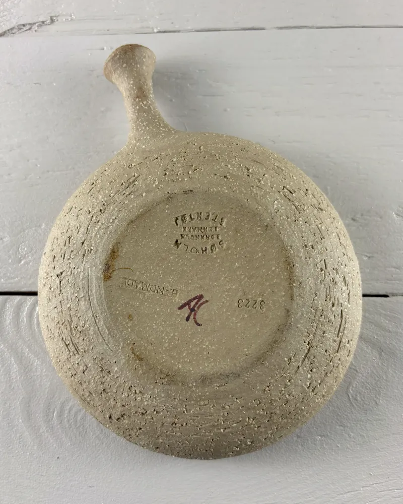 Unglazed speckled base of a Soholm stoneware candle holder with handle, stamp and model number 3223