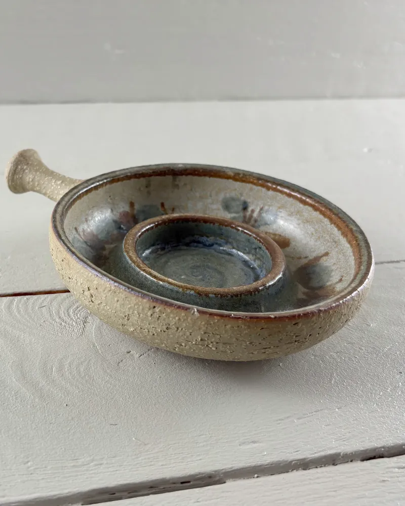 Side view of the large Soholm candle holder with handle, raised socket and unglazed speckled exterior