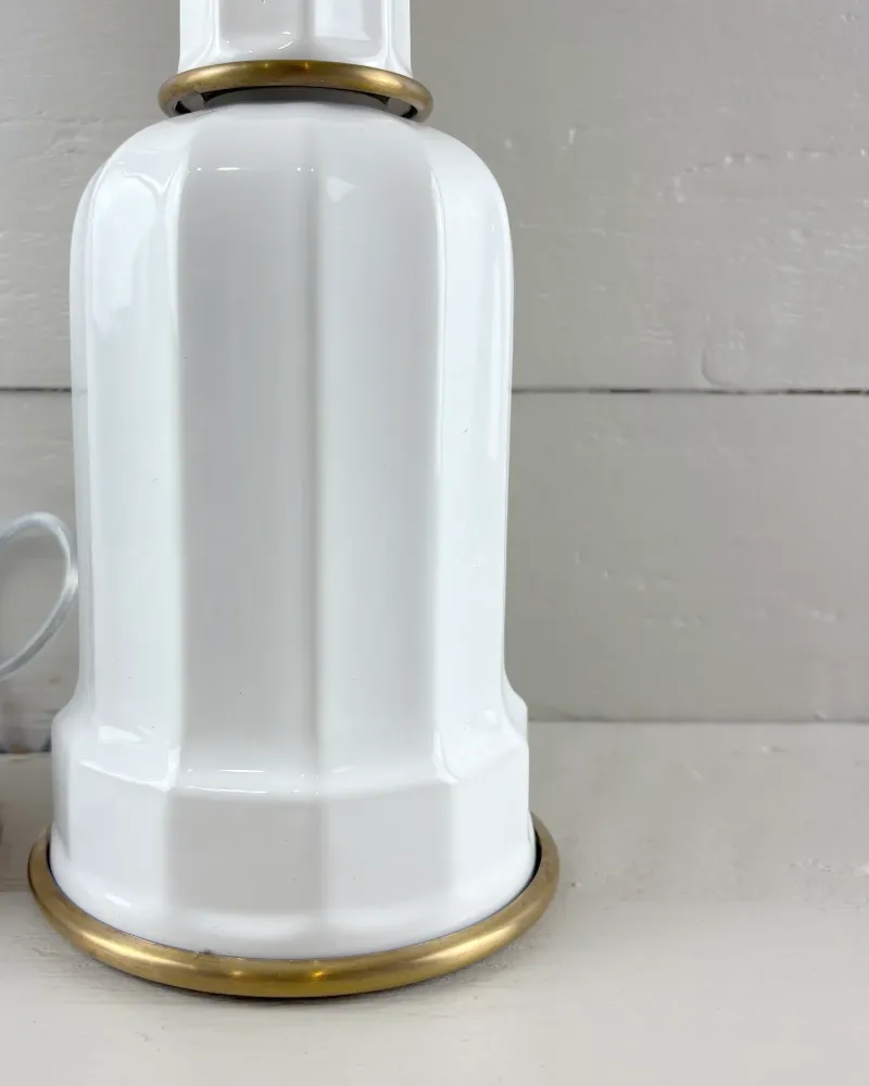 Faceted white porcelain base of a Soholm Heiberg lamp with brass foot ring on white boards