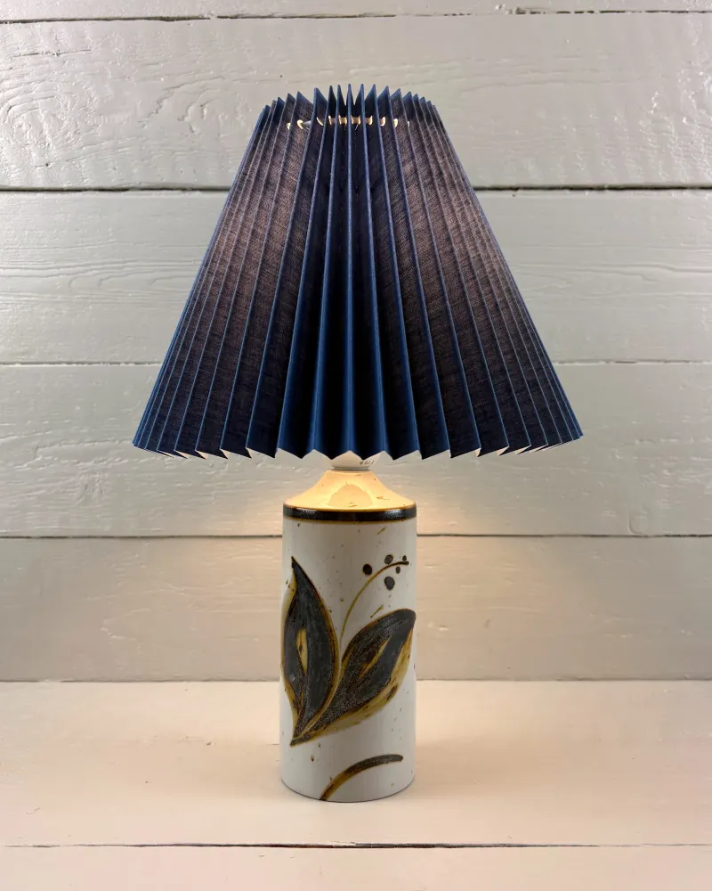 Soholm Lilia 1221 stoneware table lamp, lit, with an illustrative blue pleated shade (shade not included)