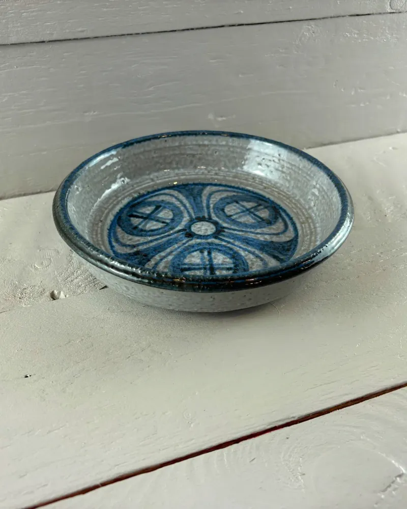 Round Søholm bowl with blue painted decoration seen at a low angle, showing the grey glazed exterior