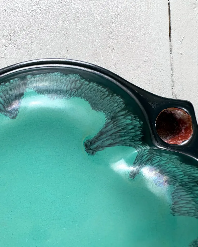 Close-up of turquoise and dark feathered glaze next to a brown candle cup, Upsala-Ekeby candle holder